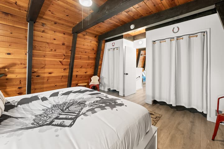 Bedroom #1: This gorgeous primary bedroom suite has a California king bed, wood floor, modern rustic decor, and access to the upper loft.