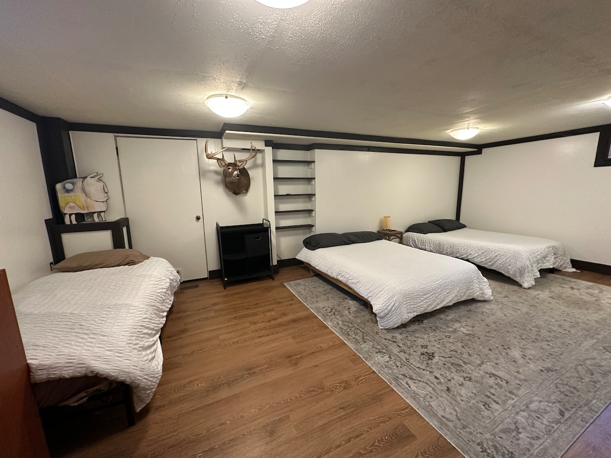 The finished basement has 2 double size futons and a comfy single bed. It also has a desk for a workspace. 