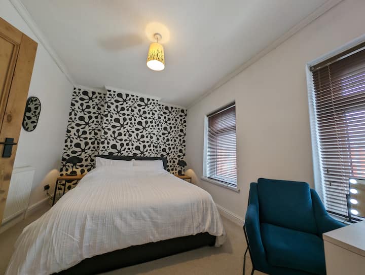 50" Samsung TV, საგარდერობო მაგიდა შუქდიოდური მაკიაჟის სარკით, დიდი ხავერდის სკამი, ღია გარდერობი საკიდებით, ორი გვერდითი მაგიდა თანამედროვე ლამპებით 