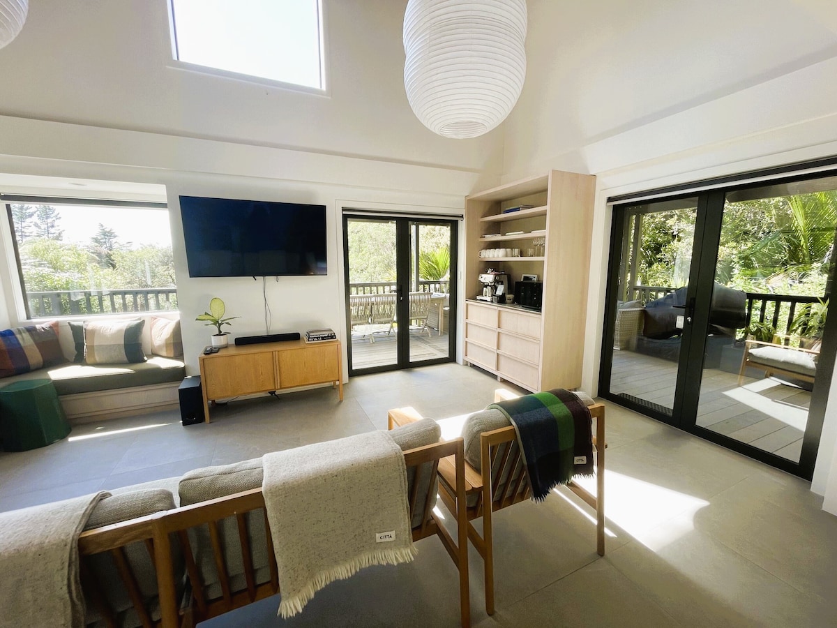 Modern minimalist scandi style lodge with luxurious furnishings. Doors open onto a covered deck for maximum airflow. 