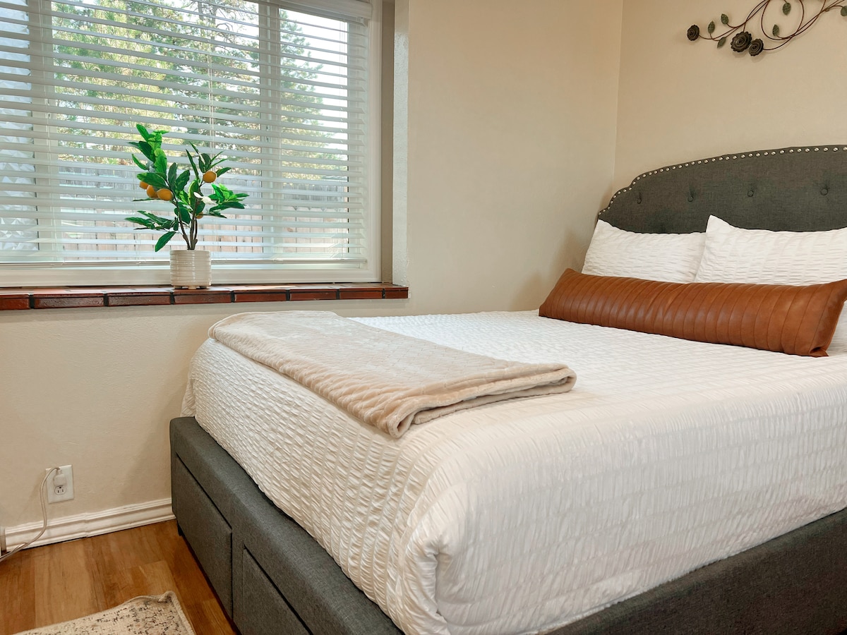 Queen bed with drawers for storage. View of the back patio out of the back window.