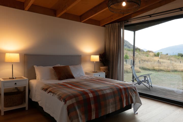 Main bedroom in its own separated space. Equipped with plush King sized bed, it's own bathroom and small office. Enormous windows capture the stunning view towards the mountains and across the lake.