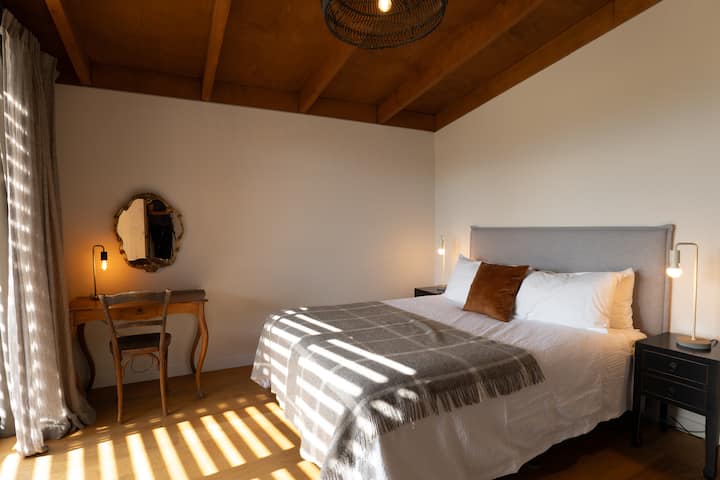King sized bed and king sized views to the mountains and lake beyond. Direct access to the deck from the room. Your own dedicated en-suite bathroom and small desk complete this bedroom.