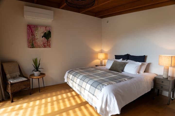 This bedroom has access directly onto the deck outside with views of the mountains and lake to the north. Setup in this photo is as a super-king bed.