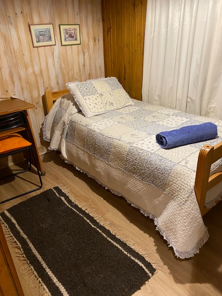 Chambre avec lit simple, draps et serviette 
Petit bureau et chaise 
Grand placard où sont rangés des jeux de société