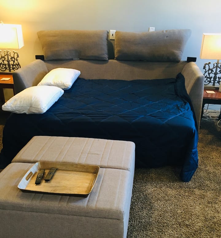 Saca el sofá cama con almohadas y ropa de cama.