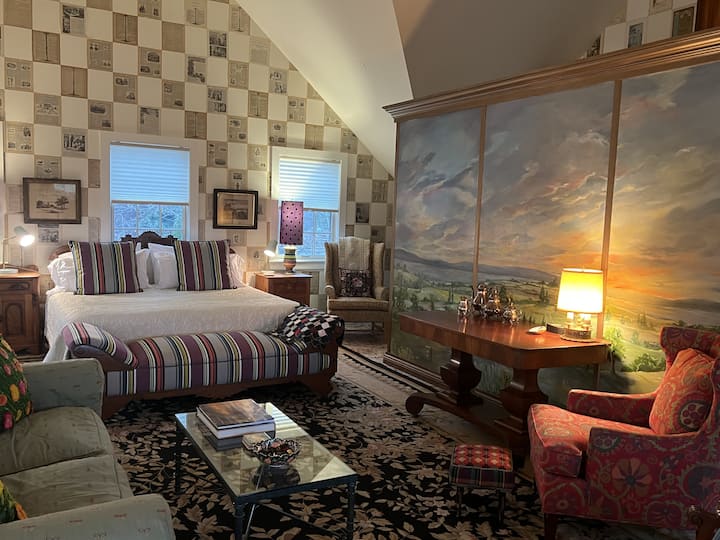 Cama tamaño king en el conservatorio y sala de estar con el mural histórico de MacKenzie-Childs de los alrededores de la Carriage House.