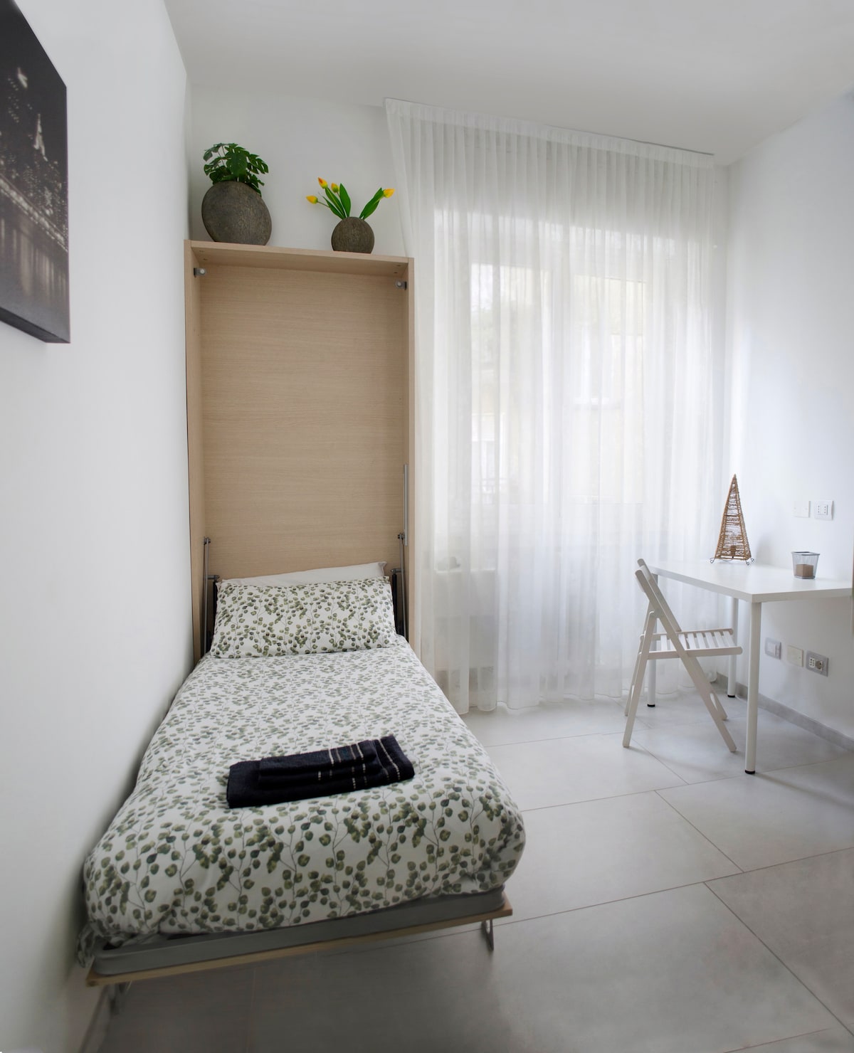 غرفة نوم مع سرير يختفي 80 × 200 سم ومكتب وخزانة حيث يمكنك تخزين ملابسك ومروحة محمولة