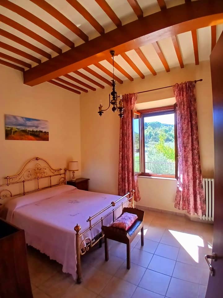 Camera matrimoniale, spaziosa e molto luminosa, con letto in ferro battuto color oro. Ambiente silenzioso e rilassante.