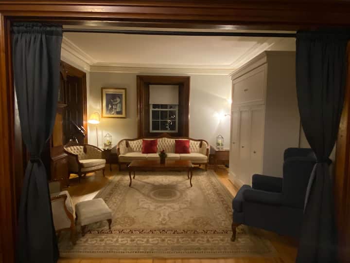 Spacious living room that easily transforms into a cozy bedroom, featuring a comfortable queen Murphy bed and privacy curtains for a restful night’s sleep. The perfect blend of function and comfort for your stay.
