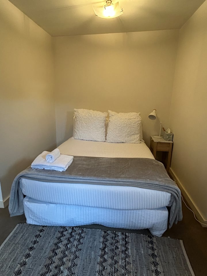 Cama doble en bungalow. No hay baño dentro de esta habitación. Accede al baño al otro lado del patio.
