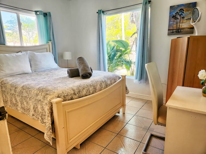 Cama doble con escritorio pequeño y TV montada