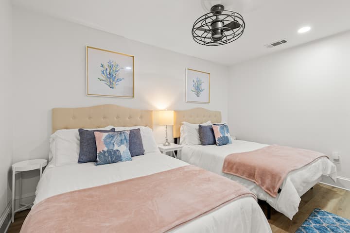 Private upstairs guest bedroom with two full size beds and overhead fan.