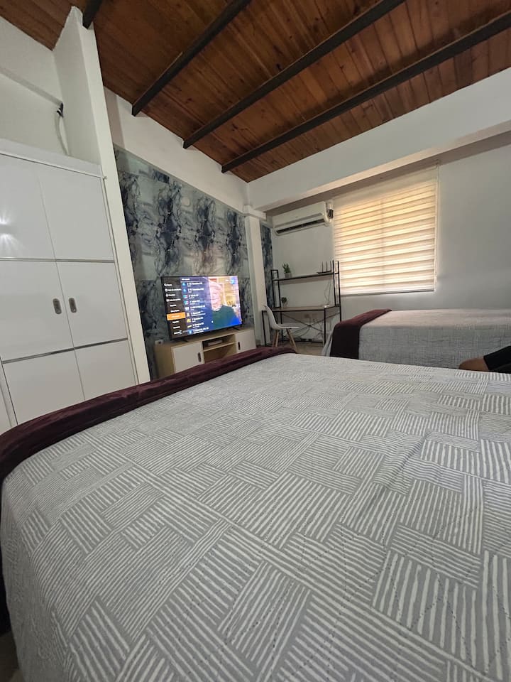 Veľká izba s dvoma manželskými posteľami, inteligentným televízorom, šatníkom. Pracovný stôl