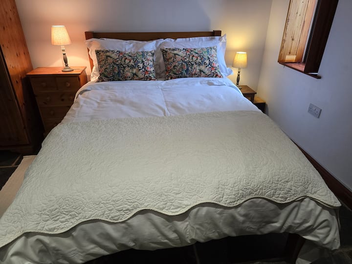 Esta es el área para dormir. Teníamos una cama doble hecha a mano, que nuestros huéspedes dicen que es muy cómoda, y la ropa de cama de calidad hotelera de 800 hilos, es lujosa. Las luces apagadas se pueden controlar de forma remota desde un interruptor portátil junto a la cama;