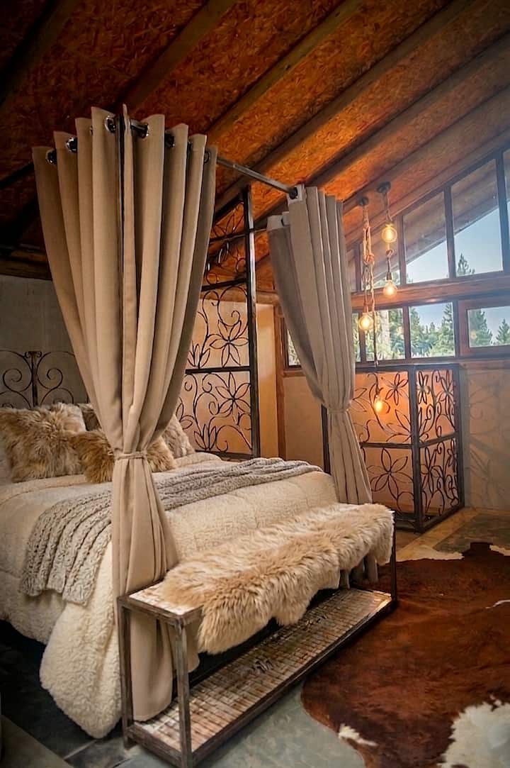Rustic charm and coziness in every detail. The four-poster bed, surrounded by delicate curtains, creates an intimate and cozy atmosphere, while the soft lighting and wooden elements add even more warmth to the space. Perfect for relaxing!