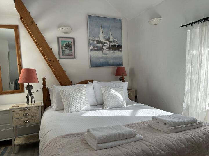 Comfy king sized bed. Ladder up to the mezzanine reading nook with a view of the sea.