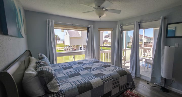 Master bedroom with gorgeous views of the beach and the ocean and the blue skies. Connects to a beautiful patio.