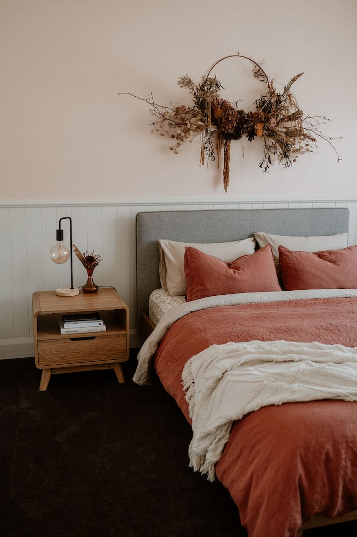 Comfy Queen Bed, with linen covers, filtered light.
