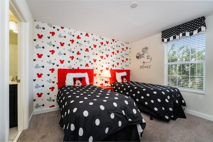 Charming Mickey Mouse-themed kids' room with playful polka-dot bedding, a magical highlight for younger guests.