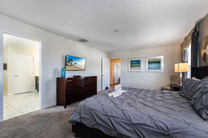 Spacious master bedroom layout with large dresser and flat-screen TV, providing plenty of comfort and storage for longer stays.