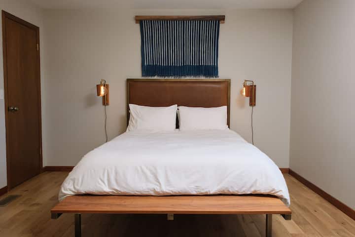 Designer queen bed with custom wall hanging