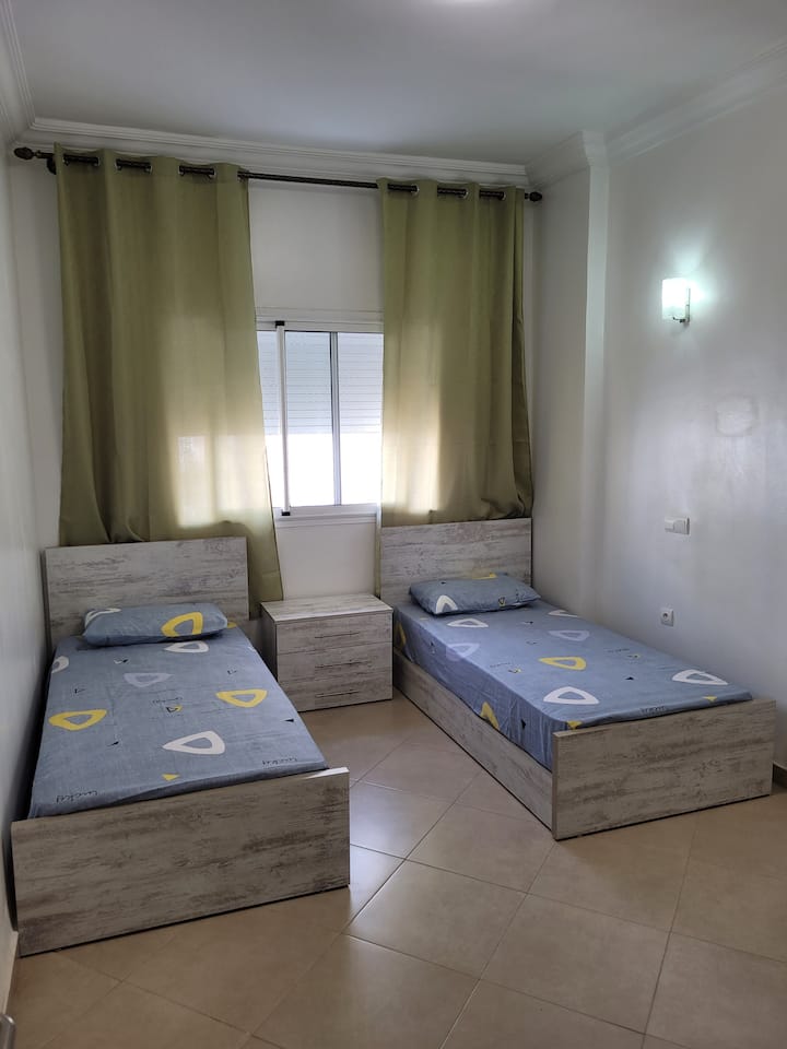 კომფორტული საძინებელი ორი ერთადგილიანი საწოლით, რომელიც იდეალურია ორი ადამიანისთვის, მყუდრო და დამამშვიდებელი ატმოსფეროთი.