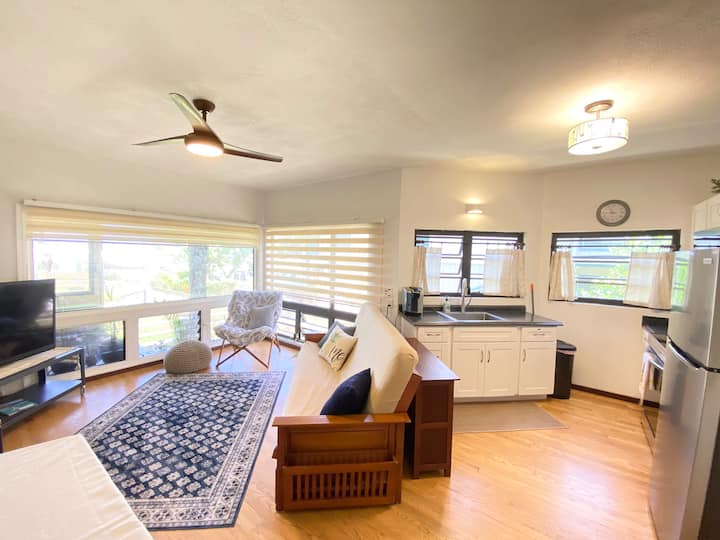 Всекидневната, трапезарията и кухнята са удобно разделени в едно просторно помещение, което се радва на постоянния океански бриз и гледа към спокойния залив.