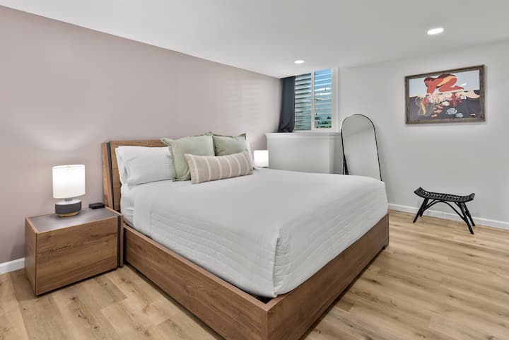 PRIMARY BEDROOM: This spacious retreat features an Italian-made king bed with a premium mattress dressed in luxurious Comphy® linens, bedside tables with lamps, a full-length mirror and dedicated air conditioning.