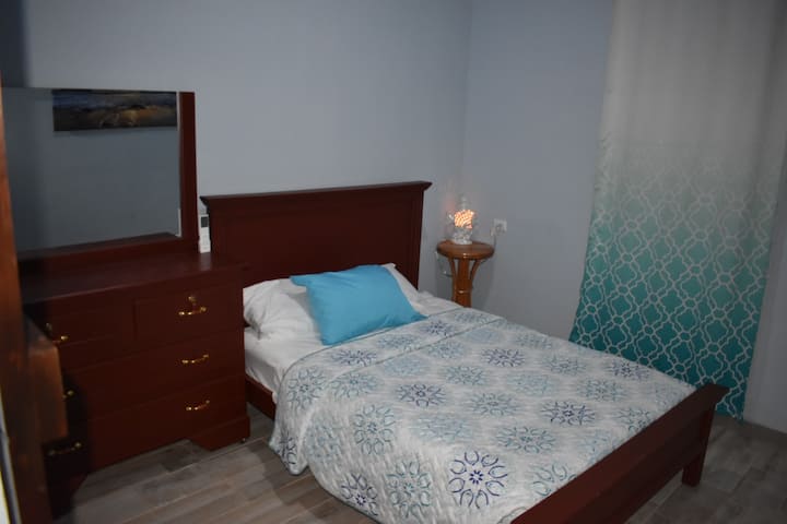 Cama tamaño full/matrimonial para dos personas con aire acondicionado y su gabetero. 