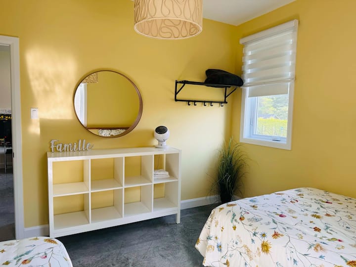 Lumineuse avec sa couleur et décoration printanière, cette chambre à deux lits double.