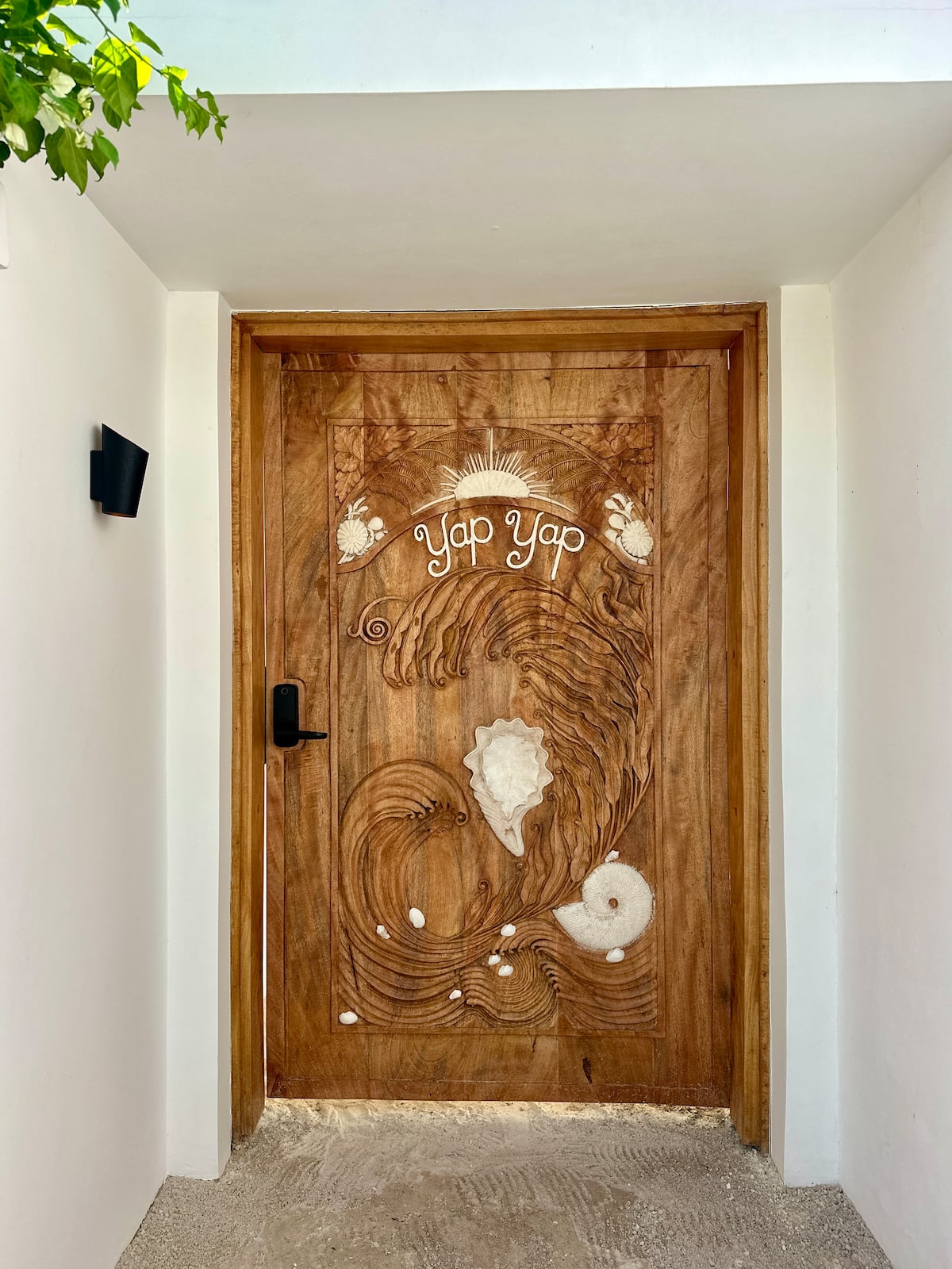 Hand-carved mango wood entrance door of YapYap Villa