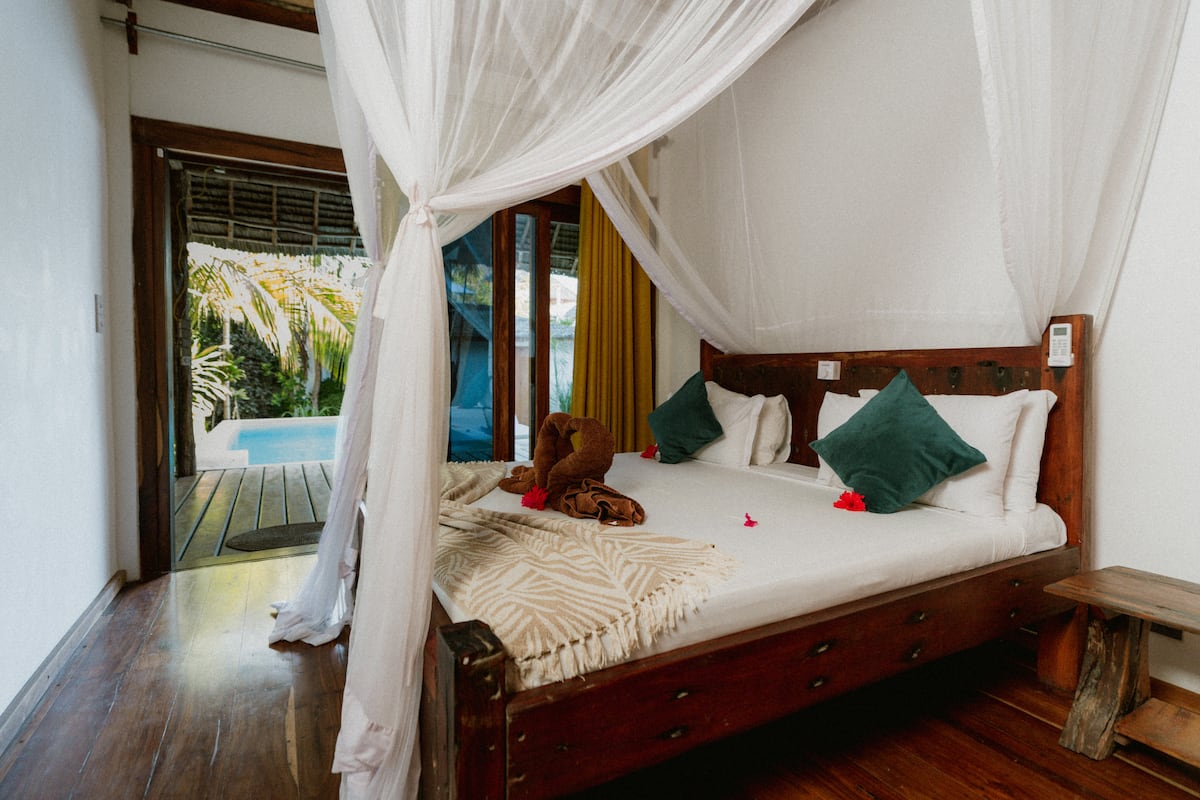 King bedroom with canopy bed opening to the pool