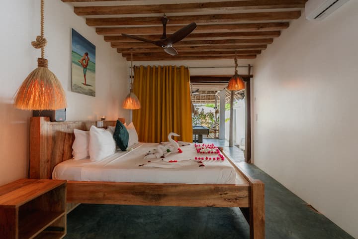 Schlafzimmer mit geflochtener Lampe in der YapYap Villa, Paje, Zanzibar