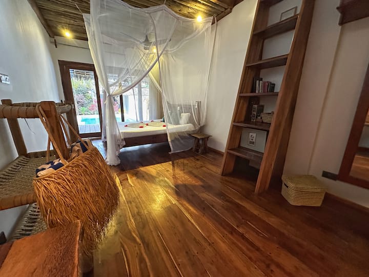 Schlafzimmer mit Tagesbett und Holzboden in der YapYap Villa, Paje, Zanzibar