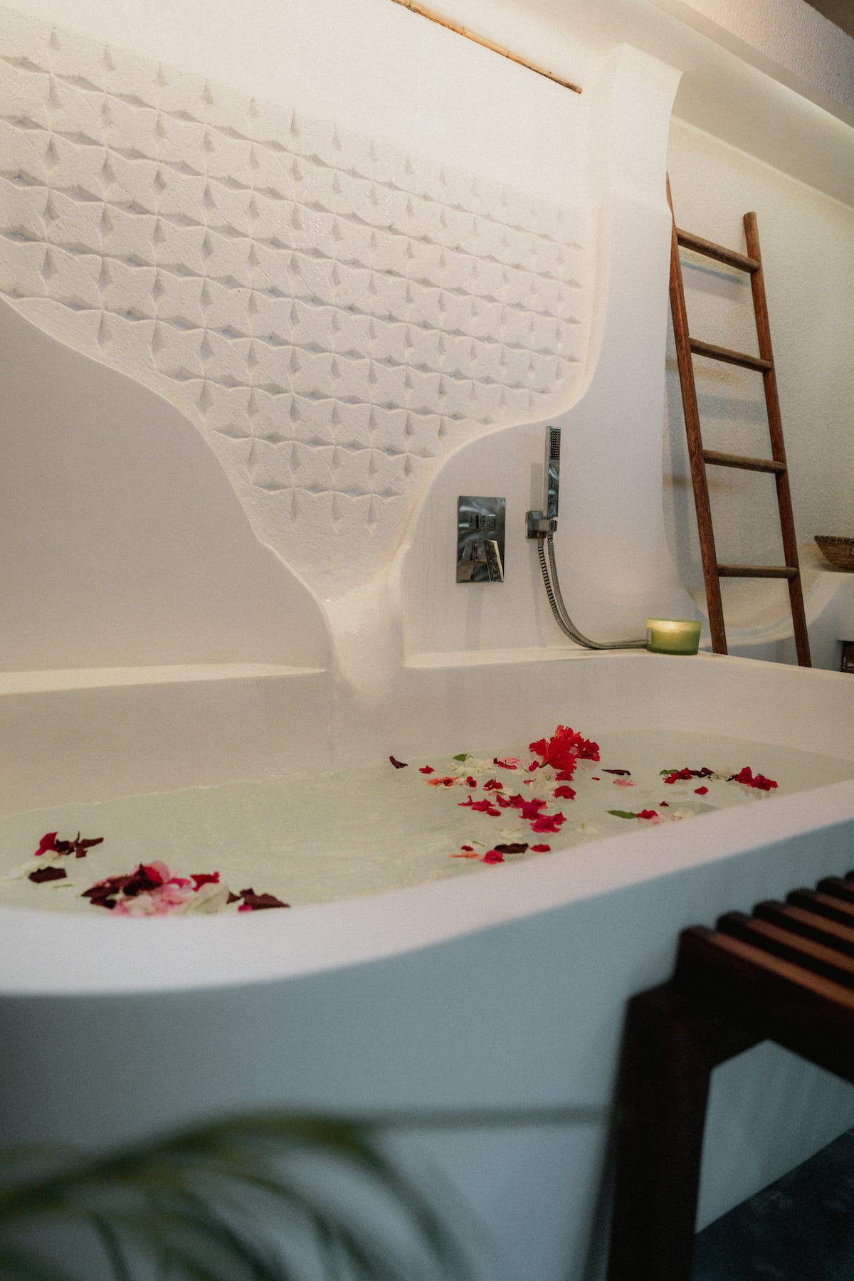 Sculpted white bathtub with rose petals