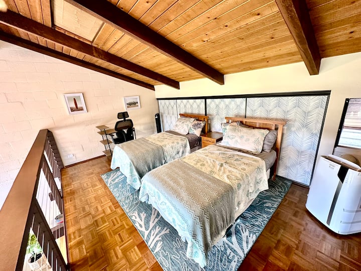 Ჩვენი მყუდრო ლოფტი გადაჰყურებს მისაღებ ოთახს, რომელშიც ორი ტყუპი საწოლია, რომლებიც იდეალურია მშვიდი ძილისთვის.