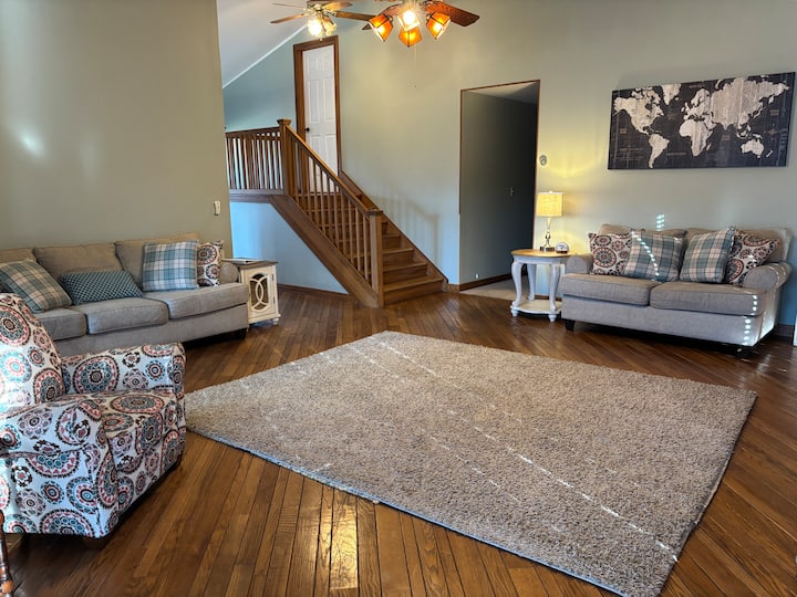 Main living room with ceiling fans and seating for 6 to watch tv.
