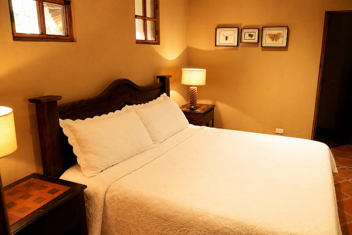 Recámara acogedora con techos altos, aire acondicionado y luz natural. Diseño despejado pensado para descansar después de un día al aire libre. Ubicado en una finca privada donde la naturaleza te rodea y el entorno cambia con las estaciones. Cómodo y funcional para disfrutar.
