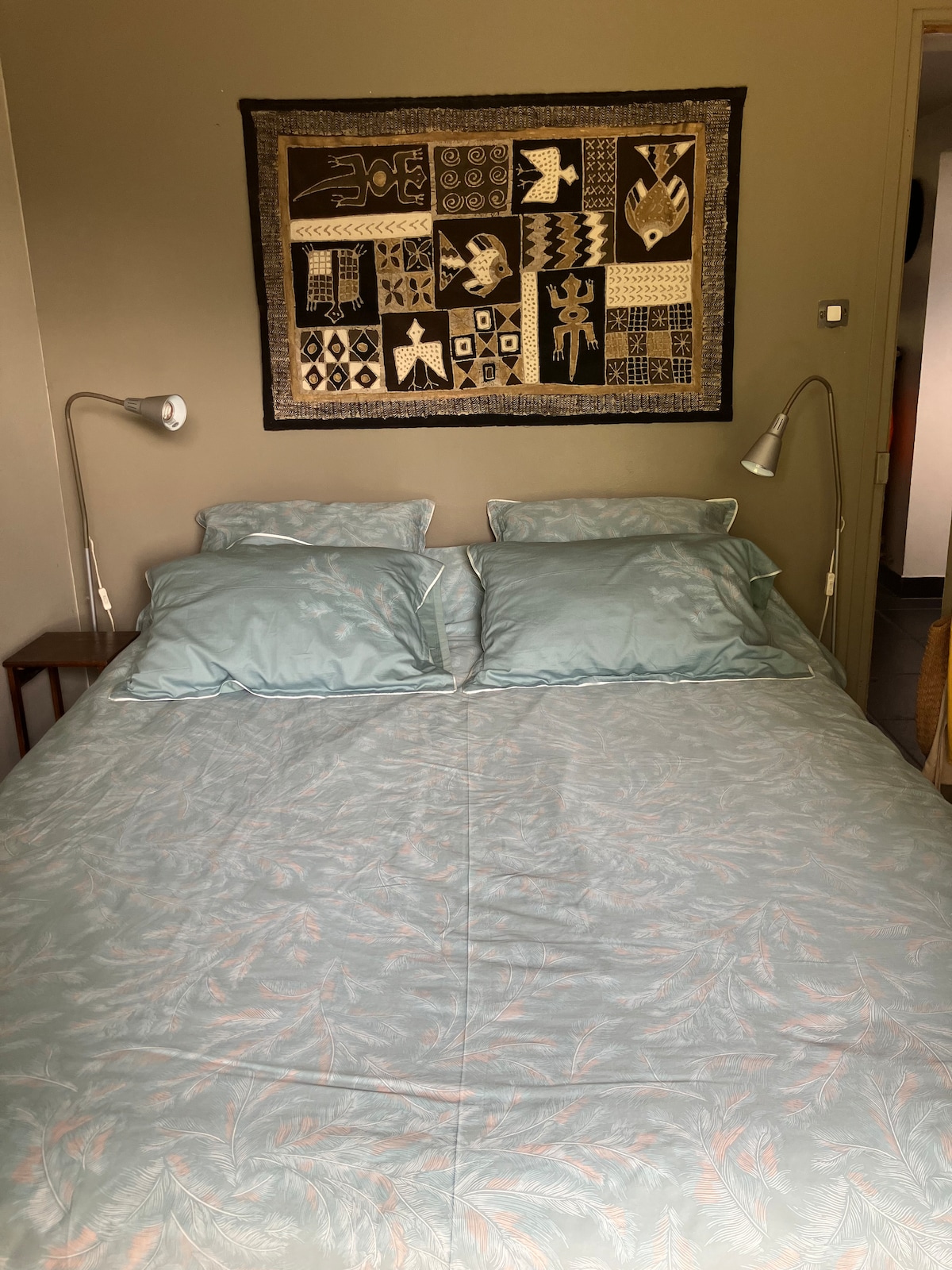 Dhoma e gjumit 1 në katin e kopshtit me një dritare që hapet në kopsht me tarracë të vogël private me një tavolinë të rrumbullakët dhe dy karrige plus çadër.