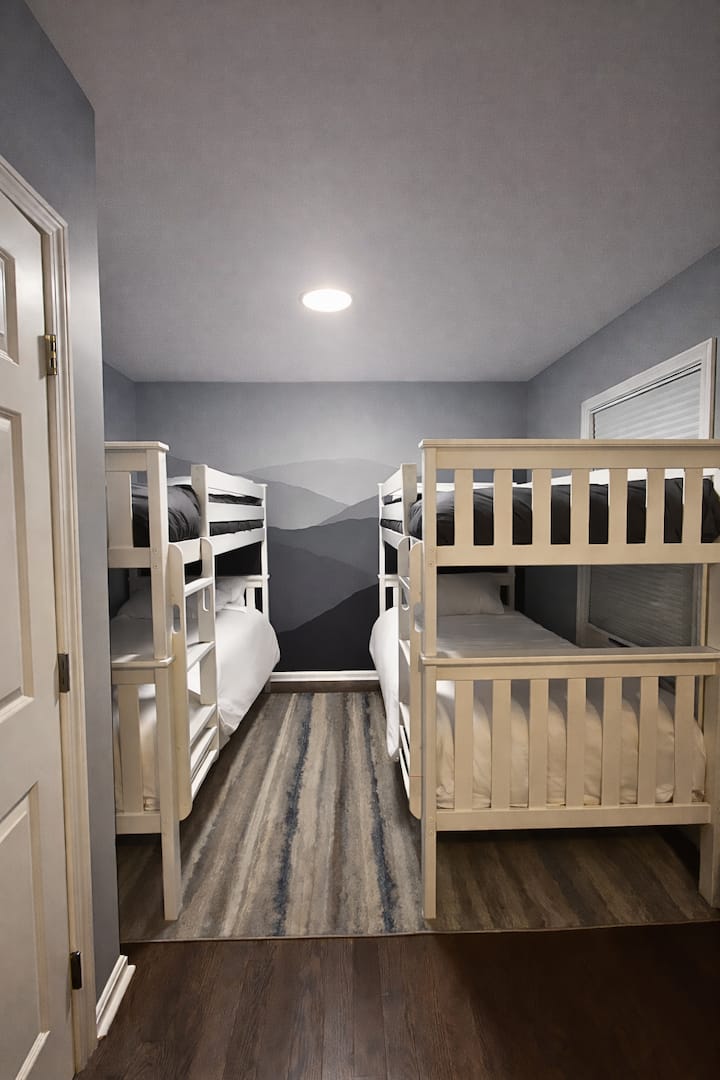 Comfortable bunk room with two twin-over-twin beds. The lower bunk features a plush 12” memory foam mattress (ideal for adults) while the upper bunk has an 8” memory foam mattress, perfect for kids or lighter sleepers under 150 lbs.
