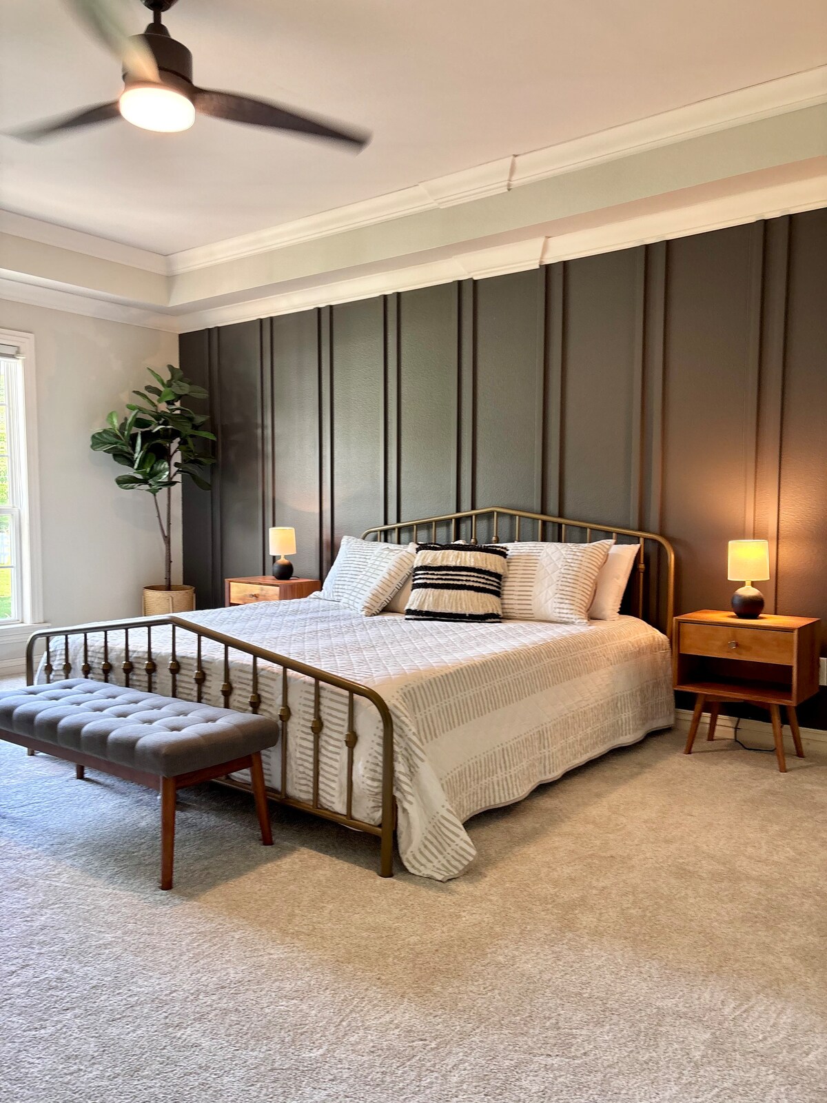 غرفة نوم رئيسية في الطابق الرئيسي مع سرير بحجم كينج، وخزانة ملابس ضخمة مع أرفف مدمجة، وخزانة ملابس، وحمام داخلي  