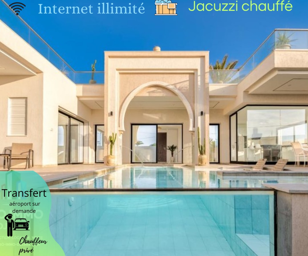 The villa features a modern design with large glass doors that open to a private pool area. Sunlight reflects off the water, and the surrounding terrace is lined with palm trees. Spacious living areas are visible through the glass panels, offering an indoor-outdoor flow.