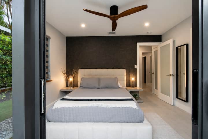La chambre 2 a un lit queen size et des portes coulissantes qui donnent sur la cour arrière privée.