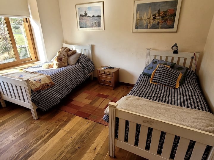 dhomë gjumi e madhe me 2 krevate tek me pamje të bukur nga kopshti 