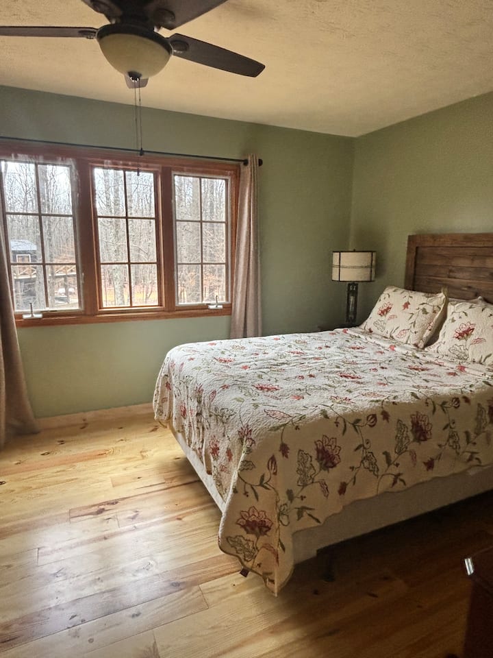 Upstairs master suite with queen-sized bed will leave you feeling like you are in a treehouse when you look out the windows.