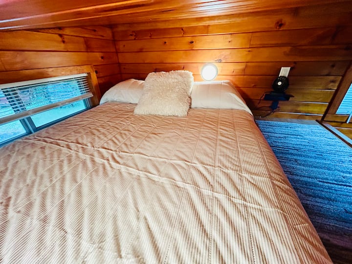 Оттеглете се в лофта с голямо двойно легло след ден навън и заспете под успокояващите звуци на гората, с меко спално бельо и стени от кедър, създаващи спокойно и възвишено убежище.