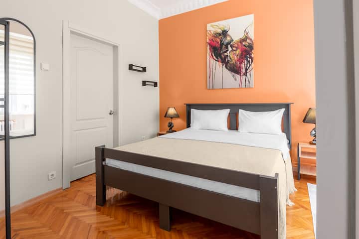 上品なアート作品が飾られた温かくおしゃれな寝室。