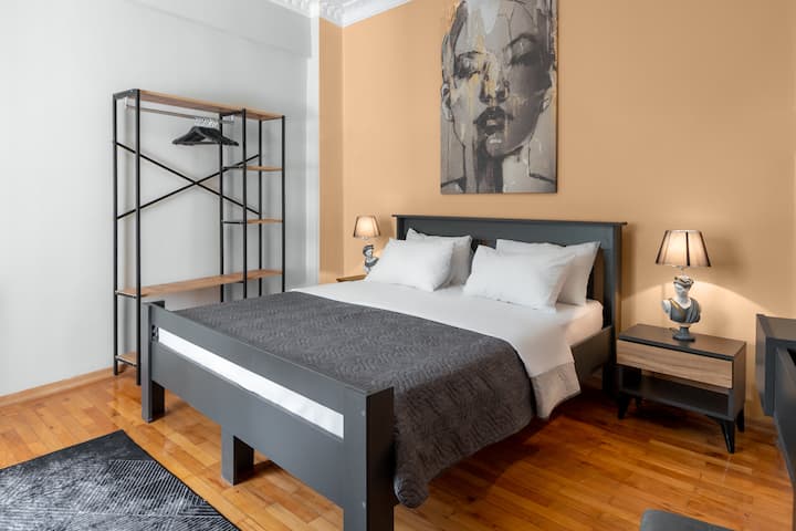 スタイリッシュなダブルベッドと暖かい照明のある快適な寝室。