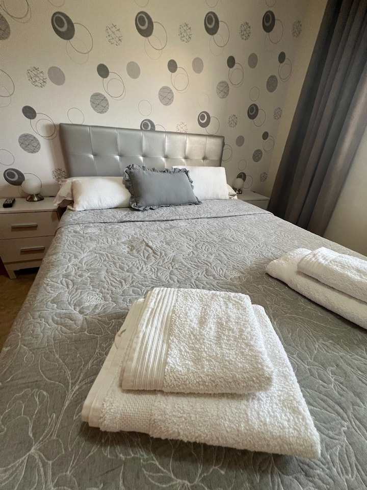 Habitación secundaria con cama matrimonial y televisión. Dispone de cajoneras para cada huésped, armario, set de toallas y una cómoda para las sábanas.